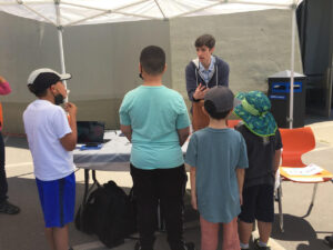 Presenter talks with a group of students