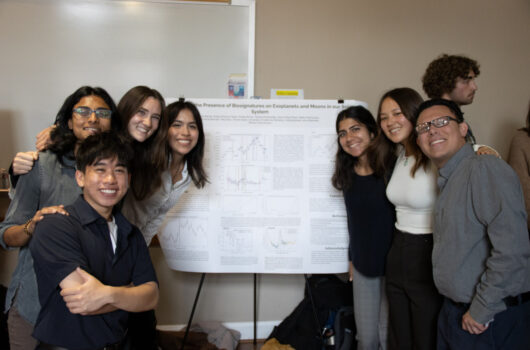 Group of students around scientific poster