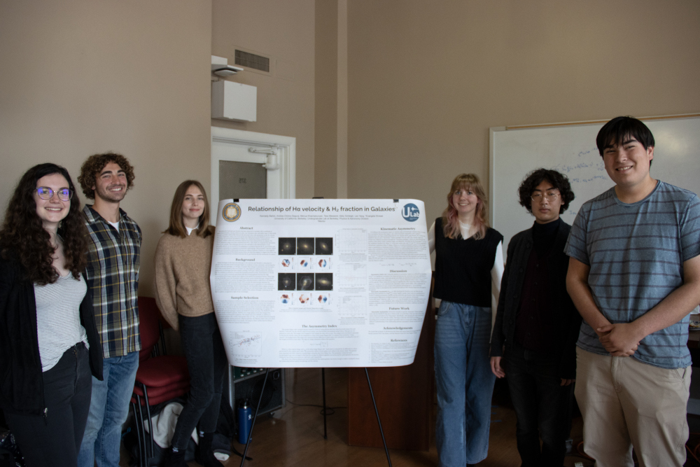 Students cluster around scientific poster