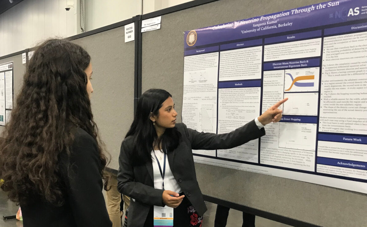Group of students clustered around a poster presentation